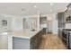 Bright kitchen featuring a large island, gray cabinets, stainless steel appliances, and wood-look tile flooring at 17300 W Dahlia Dr, Surprise, AZ 85388