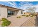 View of backyard with paved patio, desert landscaping, and block fence at 17347 W Chama Dr, Surprise, AZ 85387
