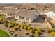 An aerial view of a home's backyard featuring mature landscaping, a metal fence, and desert-style ground covering at 17347 W Chama Dr, Surprise, AZ 85387
