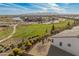 An aerial shot shows a community park, lake, and clubhouse amidst desert landscaping and mountain views at 17347 W Chama Dr, Surprise, AZ 85387