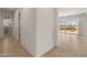 Bright hallway with tile flooring leads to an open living area with sliding glass doors at 17347 W Chama Dr, Surprise, AZ 85387