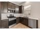 Well-equipped kitchen with stainless steel appliances and dark wood cabinetry at 17347 W Chama Dr, Surprise, AZ 85387