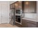 This kitchen showcases stainless steel appliances including double ovens and a refrigerator at 17347 W Chama Dr, Surprise, AZ 85387
