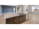 Kitchen island features a stainless steel dishwasher, undermount sink and Quartz countertop with dark wood cabinets at 17347 W Chama Dr, Surprise, AZ 85387