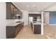 Well appointed kitchen boasts stainless steel appliances, dark wood cabinets, and quartz countertop at 17347 W Chama Dr, Surprise, AZ 85387