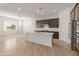 Bright, open-concept kitchen with stainless steel appliances, a large island, and dark wood cabinetry at 17347 W Chama Dr, Surprise, AZ 85387