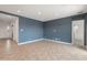Open living room with ceramic tile flooring, blue accent wall, recessed lighting, and a doorway to the bedroom at 17347 W Chama Dr, Surprise, AZ 85387
