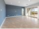 Spacious living room featuring neutral tile flooring, recessed lighting, and sliding glass doors to the backyard at 17347 W Chama Dr, Surprise, AZ 85387