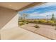 Covered patio showcasing view of desert landscaping and wrought iron fence at 17347 W Chama Dr, Surprise, AZ 85387