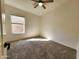 Carpeted bedroom featuring a ceiling fan and natural light from the bright window at 1771 E Erie St, Gilbert, AZ 85295