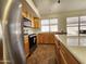 Well-lit kitchen with stainless steel appliances, wood cabinetry, and quartz countertops at 1771 E Erie St, Gilbert, AZ 85295