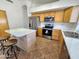 Spacious kitchen with an island, stainless steel appliances, and wood cabinets for ample storage at 1771 E Erie St, Gilbert, AZ 85295