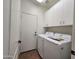 Functional laundry room with a modern washer and dryer, white cabinets, and tile floors at 1771 E Erie St, Gilbert, AZ 85295
