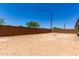 Large backyard space enclosed by a tall, brick wall, offering privacy and potential at 20570 S 216Th Pl, Queen Creek, AZ 85142