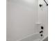 A clean white bathtub with black fixtures and a shelf adds style and functionality to this bathroom at 20570 S 216Th Pl, Queen Creek, AZ 85142