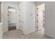 Bright hallway with tile floors and white doors leads to carpeted bedrooms, providing a modern, clean aesthetic at 20570 S 216Th Pl, Queen Creek, AZ 85142