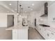 Elegant kitchen with an eat-in island, white cabinets, stainless hood, and tiled backsplash at 20570 S 216Th Pl, Queen Creek, AZ 85142