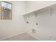 Bright laundry room featuring a window, built-in shelf, and tile floors at 20570 S 216Th Pl, Queen Creek, AZ 85142