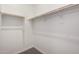 A simple white walk-in closet with wooden rods and a carpeted floor for ample storage at 20570 S 216Th Pl, Queen Creek, AZ 85142