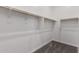 A simple walk-in closet with wooden rods and carpeted floor providing storage space at 20570 S 216Th Pl, Queen Creek, AZ 85142