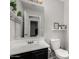 This well-lit bathroom features a large mirror, toilet, and sink, and decor shelves at 25589 W Pleasant Ln, Buckeye, AZ 85326