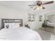 Bright bedroom features natural light from two windows, carpet flooring, a ceiling fan, and mirrored closet doors at 25589 W Pleasant Ln, Buckeye, AZ 85326