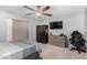 Spacious bedroom has carpet flooring, a ceiling fan, and features closet space, dresser, and TV at 25589 W Pleasant Ln, Buckeye, AZ 85326