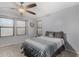 Comfortable bedroom with two windows providing natural light, carpet flooring, a ceiling fan, and soft gray walls at 25589 W Pleasant Ln, Buckeye, AZ 85326