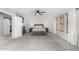 Bright primary bedroom features a ceiling fan, carpeting, three windows, and neutral decor at 25589 W Pleasant Ln, Buckeye, AZ 85326