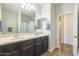 Bathroom featuring double sinks, a large mirror, and tile flooring at 25742 N 103Rd Dr, Peoria, AZ 85383