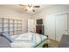 Bedroom with a TV, closet, shelving, and a bed with a patterned quilt at 25742 N 103Rd Dr, Peoria, AZ 85383