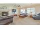 Comfortable living room with a fireplace, ceiling fan, and ample natural light at 25742 N 103Rd Dr, Peoria, AZ 85383
