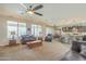 Spacious living room with seamless flow into the kitchen and dining area, enhanced by natural light at 25742 N 103Rd Dr, Peoria, AZ 85383