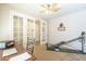 Bright office space with french doors, a ceiling fan, and ample room for a desk and exercise equipment at 25742 N 103Rd Dr, Peoria, AZ 85383