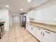 Bright kitchen features granite countertops, white cabinets, stainless steel refrigerator, and tile floors at 2737 W Alice Ave, Phoenix, AZ 85051