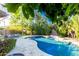 Lush backyard oasis with a sparkling pool, stone waterfall feature, and mature landscaping for privacy at 2744 E Donato Dr, Gilbert, AZ 85298
