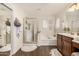 Well-lit bathroom with a glass-enclosed shower, soaking tub, and dual sinks at 2744 E Donato Dr, Gilbert, AZ 85298
