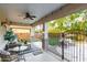 Relaxing covered patio with comfortable seating, ceiling fan, and view of the fenced backyard with artificial grass at 2744 E Donato Dr, Gilbert, AZ 85298