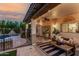 Inviting covered patio with comfortable seating, ceiling fan, and view of the fenced pool at 2744 E Donato Dr, Gilbert, AZ 85298
