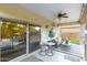 Inviting covered patio boasts ceiling fan, outdoor seating, and seamless transition to the backyard through sliding glass doors at 2744 E Donato Dr, Gilbert, AZ 85298