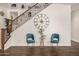 An entryway featuring a wooden staircase, blue velvet chairs, and a large decorative clock at 2744 E Donato Dr, Gilbert, AZ 85298