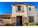 Charming home exterior with stone detailing, decorative flowers, and a cozy, welcoming front porch at 2744 E Donato Dr, Gilbert, AZ 85298