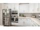Kitchen features stainless appliances, white cabinets with gold hardware, decorative backsplash and light countertops at 2744 E Donato Dr, Gilbert, AZ 85298