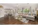 Spacious living room with sectional sofa, wood floors, and a view into the dining area and kitchen at 2744 E Donato Dr, Gilbert, AZ 85298