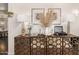 A modern living room credenza styled with lamps, art, a record player and a floral arrangement at 2744 E Donato Dr, Gilbert, AZ 85298