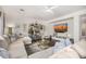 Bright living room featuring a beige sectional, wood floors, and decorative shelving unit at 2744 E Donato Dr, Gilbert, AZ 85298
