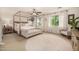 Bright and airy bedroom with a four-poster bed, seating area, and ample natural light at 2744 E Donato Dr, Gilbert, AZ 85298