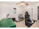 Neutral home office featuring a ceiling fan, a desk, and built-in shelves behind a rolling office chair at 2744 E Donato Dr, Gilbert, AZ 85298