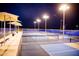 Well-lit community pickleball courts with blue surfacing, benches, and shade structures for evening games at 2744 E Donato Dr, Gilbert, AZ 85298