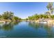 Serene view overlooking a calm lake with lush landscaping and a cascading waterfall feature at 2744 E Donato Dr, Gilbert, AZ 85298